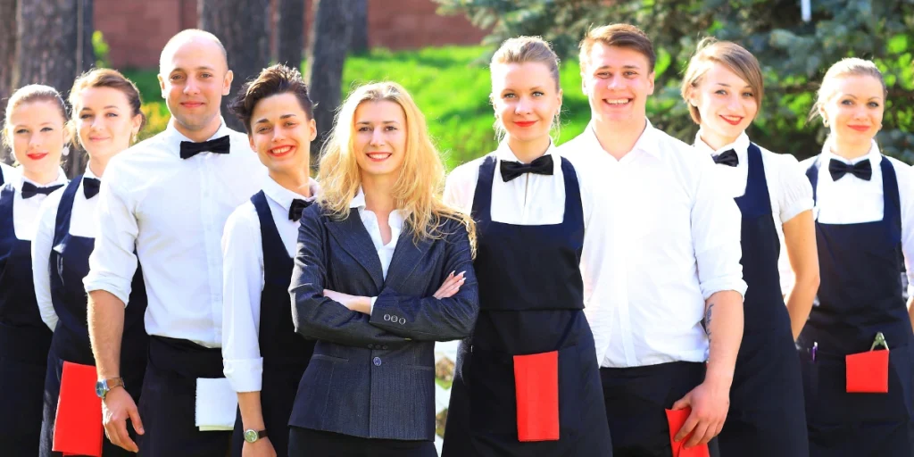 Hospitality staff group photo wearing Sustainable uniforms UAE for restaurants and catering