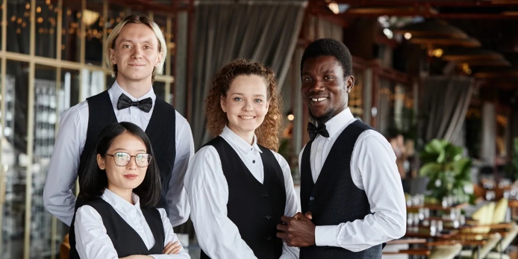 Restaurant team wearing stylish uniforms for Hospitality UAE, presenting a professional service appearance